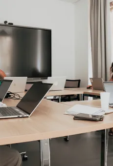 Photo de personnes travaillant sur un ordinateur dans une salle de réunion au 37Bis.
